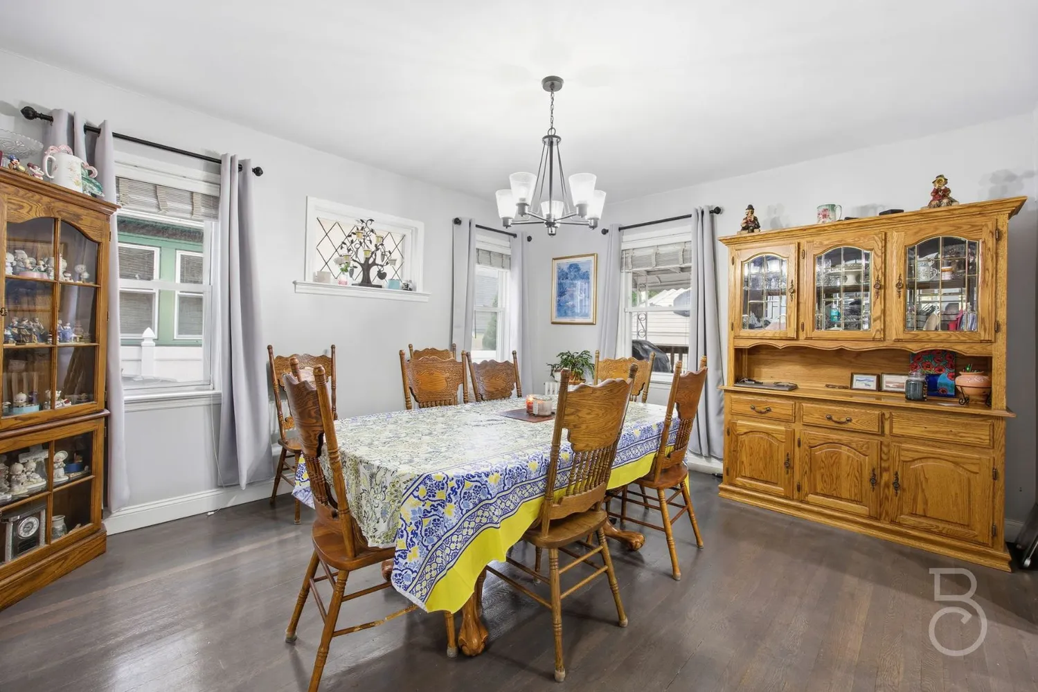 a dining room with furniture a chandelier and wooden floor