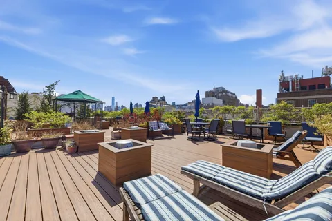 a view of a rooftop deck with couch and chairs