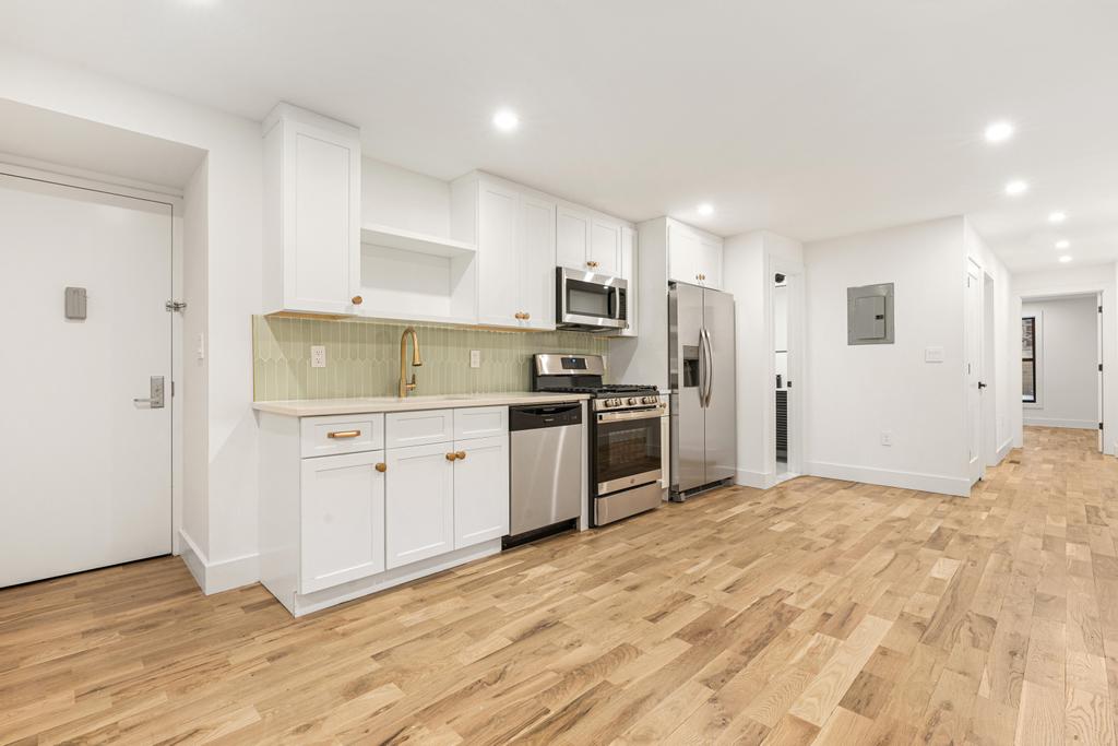 987 Sterling Place Brooklyn, NY 11213 - Photo 11 of 16 a kitchen with stainless steel appliances a refrigerator sink and cabinets