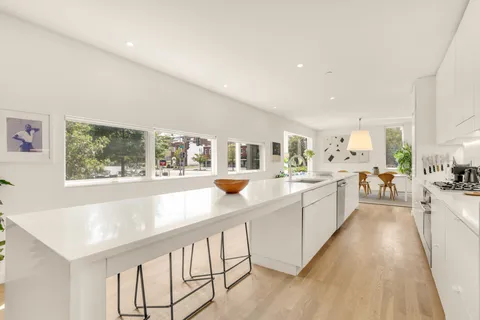 a large white kitchen with a large window