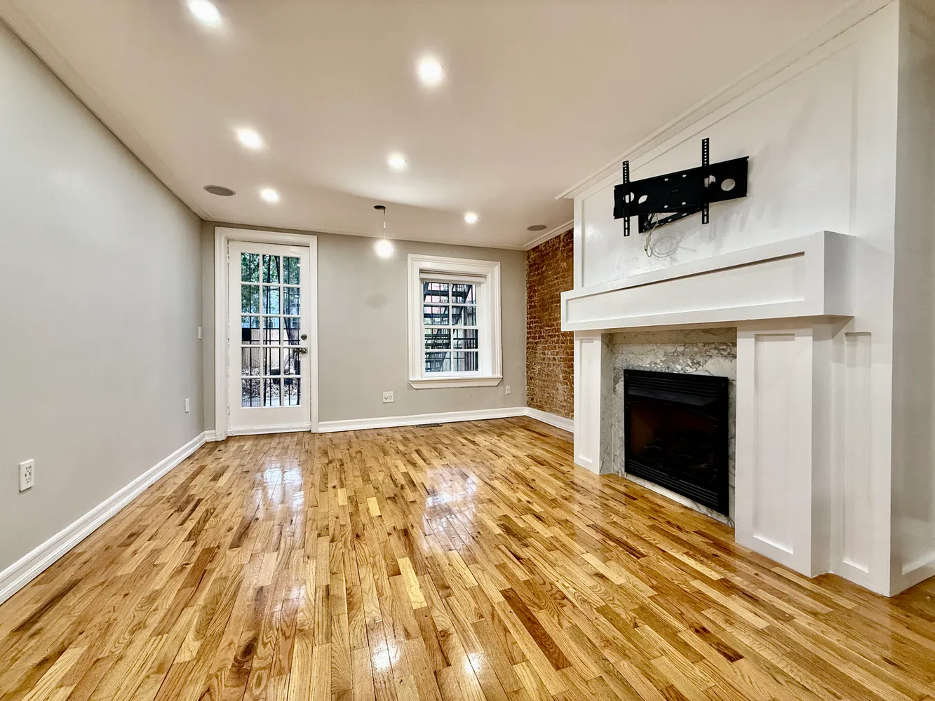 a view of an empty room with a fireplace and a window
