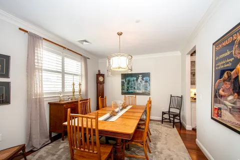a view of a dining room with furniture a chandelier and wooden floor
