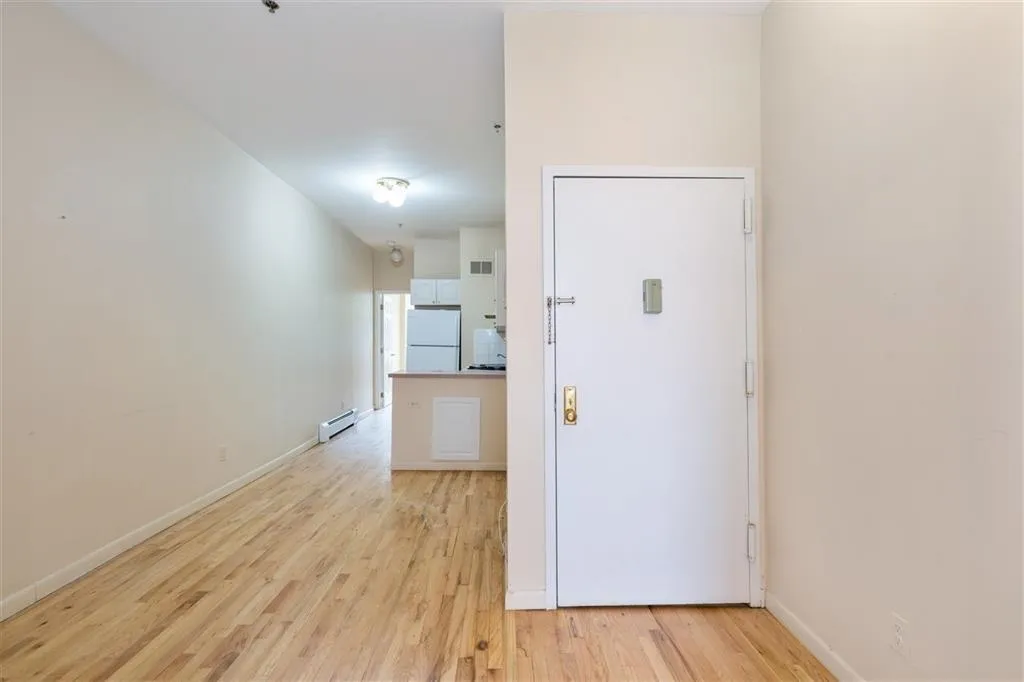 a view of empty room with wooden floor