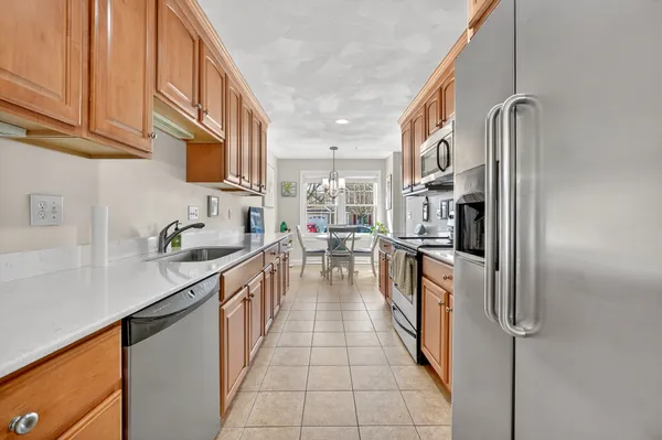 a kitchen with stainless steel appliances granite countertop a sink and a refrigerator