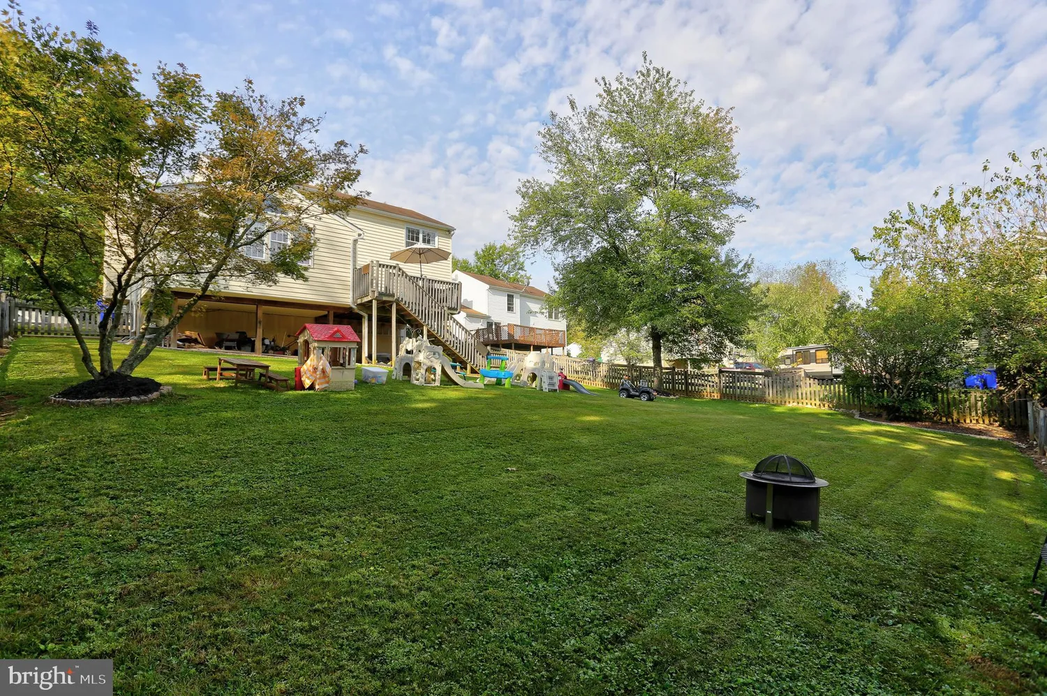 a front view of a house with garden and trees