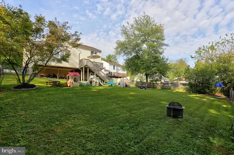 a front view of a house with garden and trees
