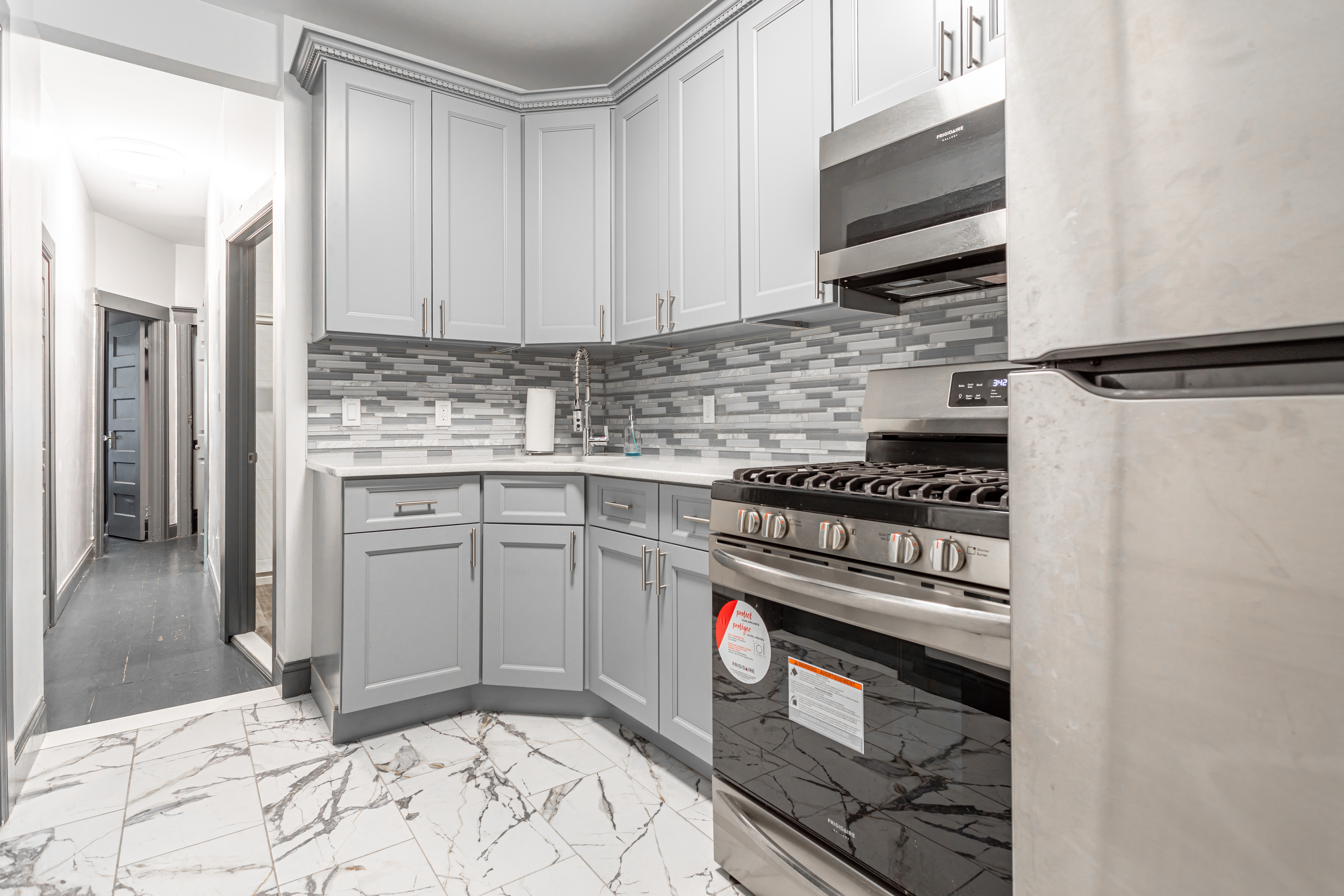 1191 Lincoln Place, Unit 1 Brooklyn, NY 11213 - Photo 8 of 13 a kitchen with stainless steel appliances granite countertop a stove a sink and a microwave