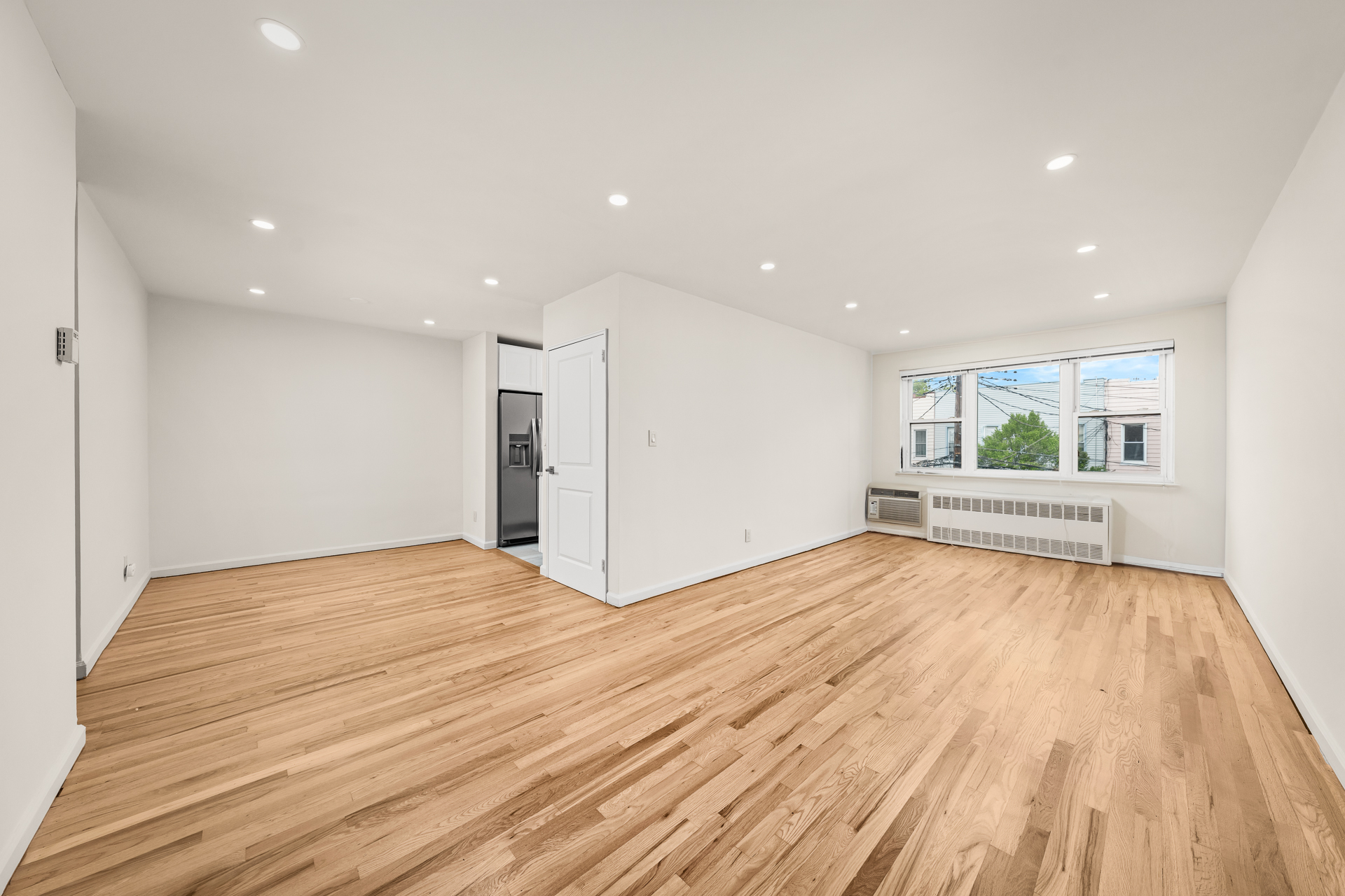 412 Fairview Avenue, Unit 1 Queens, NY 11385 - Photo 4 of 9 a view of an empty room with wooden floor and windows