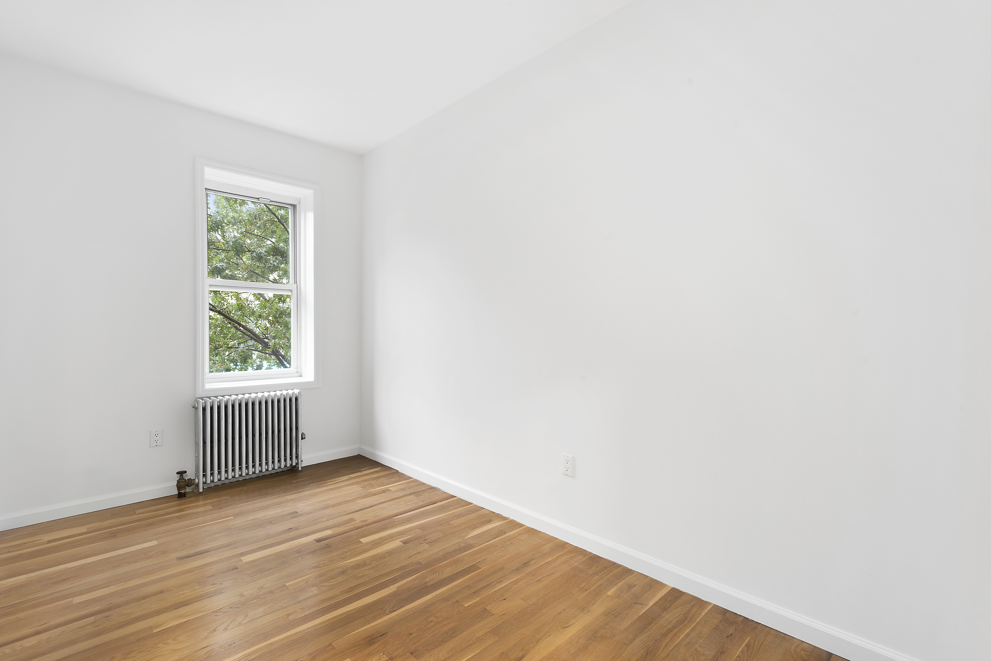 59 Stagg Street, Unit 3 Brooklyn, NY 11206 - Photo 5 of 8 a view of an empty room with wooden floor and a window
