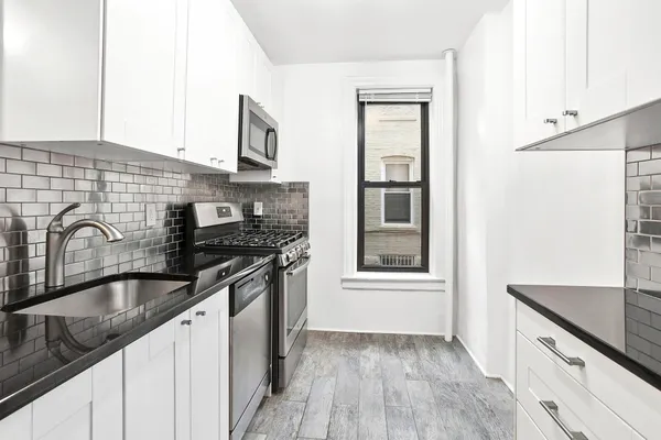 a kitchen with granite countertop a sink stove and cabinets