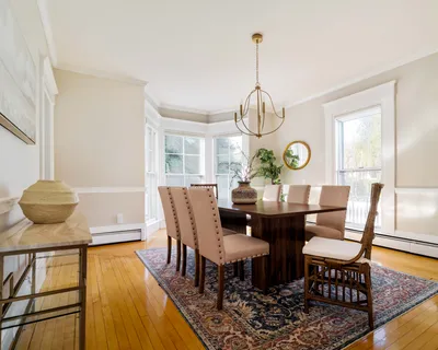 a view of a dining room with furniture a chandelier and wooden floor