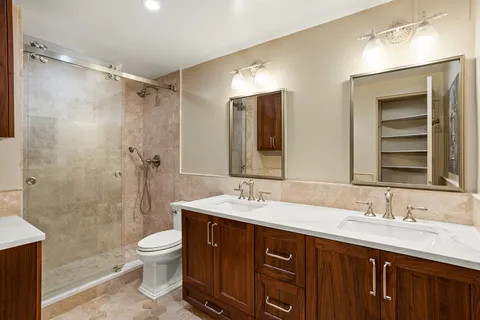a bathroom with a double vanity sink mirror and toilet