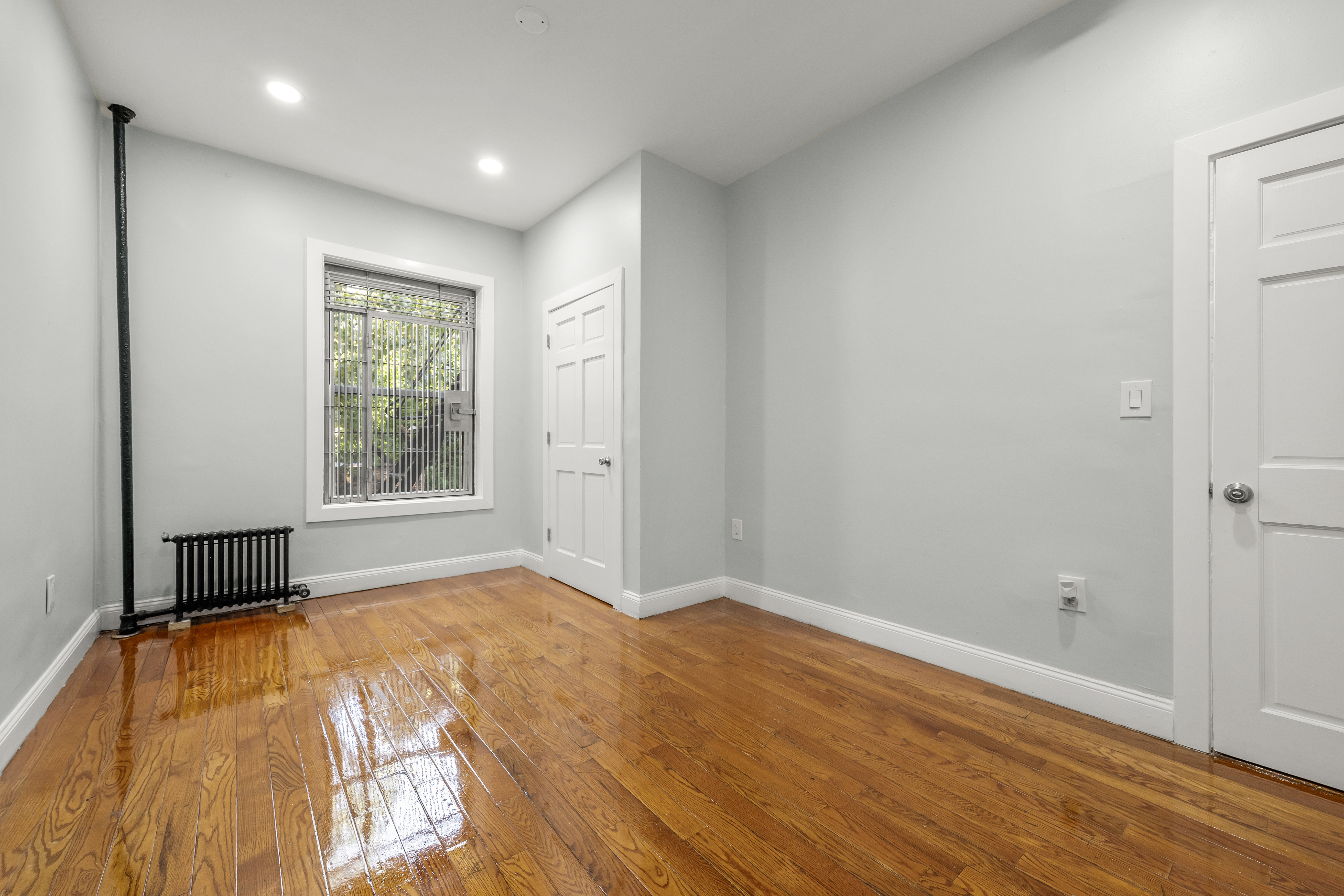 2023 Hughes Avenue Bronx, NY 10457 - Photo 9 of 63 a view of empty room with wooden floor and fan