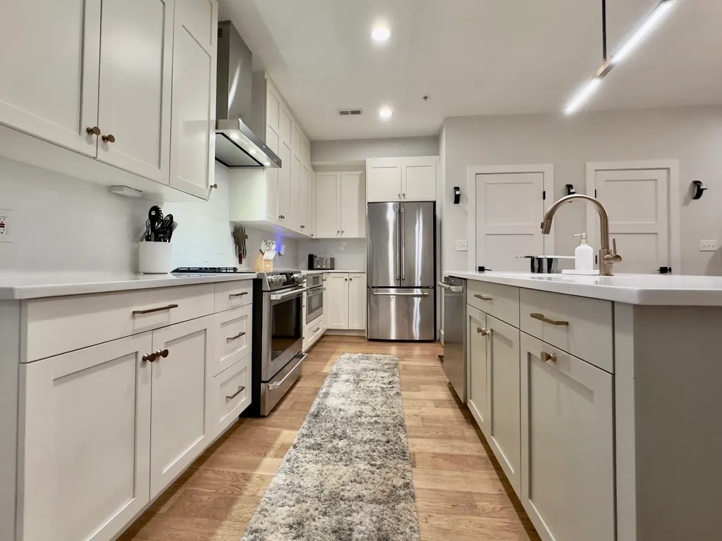 a kitchen with white cabinets and stainless steel appliances