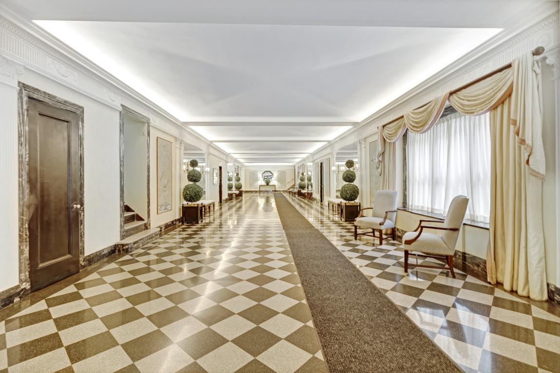 136 East 64th Street, Unit 11E Manhattan, NY 10065 - Photo 11 of 14 a hallway with furniture and a rug