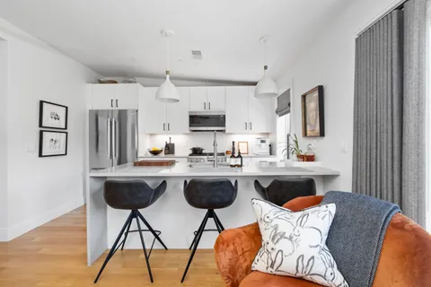 a living room with kitchen island furniture and a wooden floor