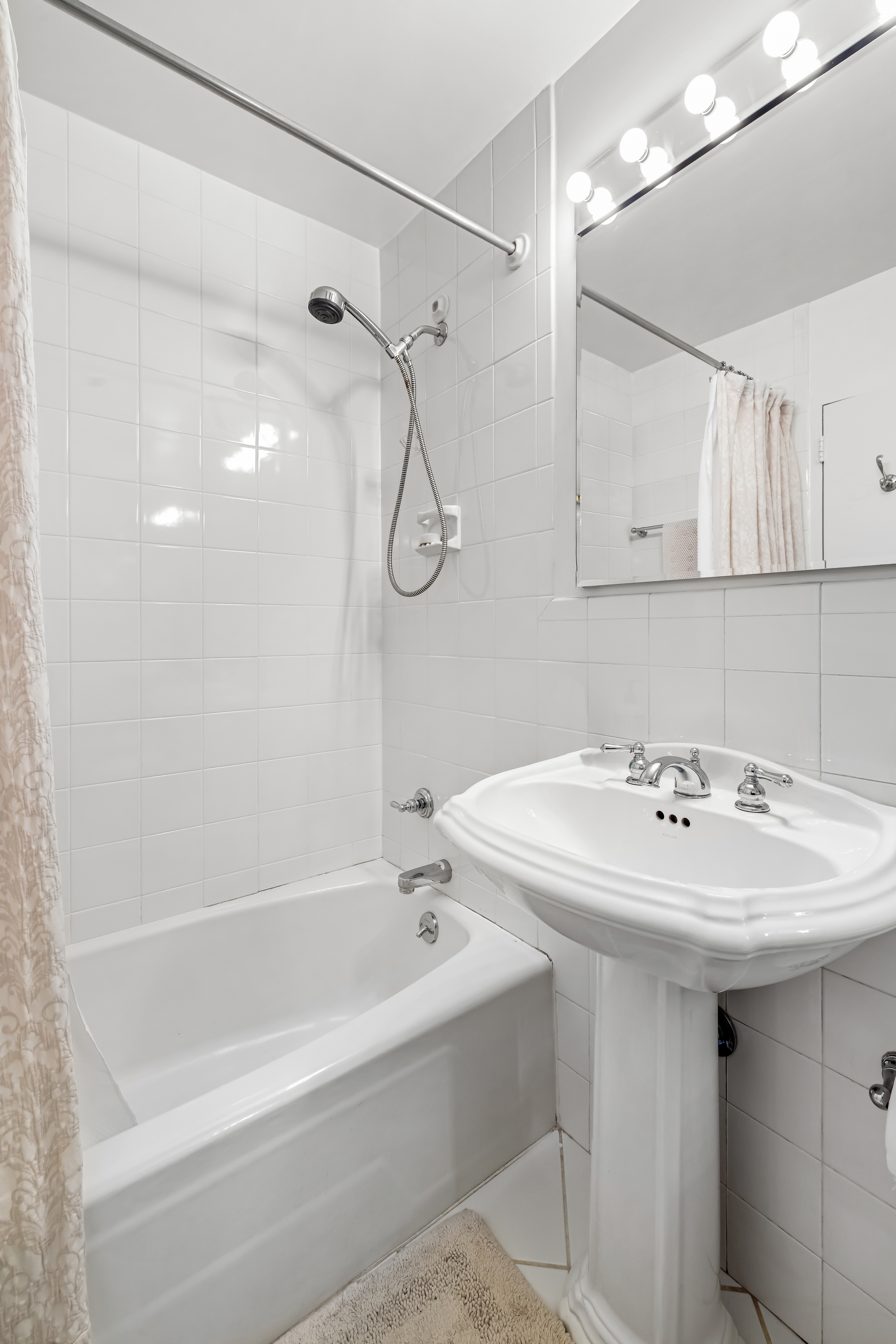 123 East 75th Street, Unit 5C Manhattan, NY 10021 - Photo 6 of 8 a bathroom with a sink a mirror and a shower