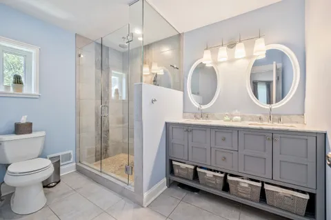 a spacious bathroom with a double vanity sink mirror and toilet