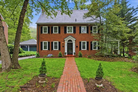 front view of a brick house with a yard