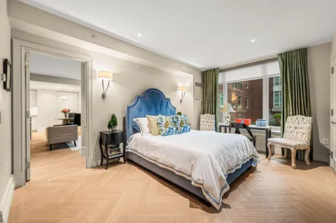 a bedroom with a bed and large windows