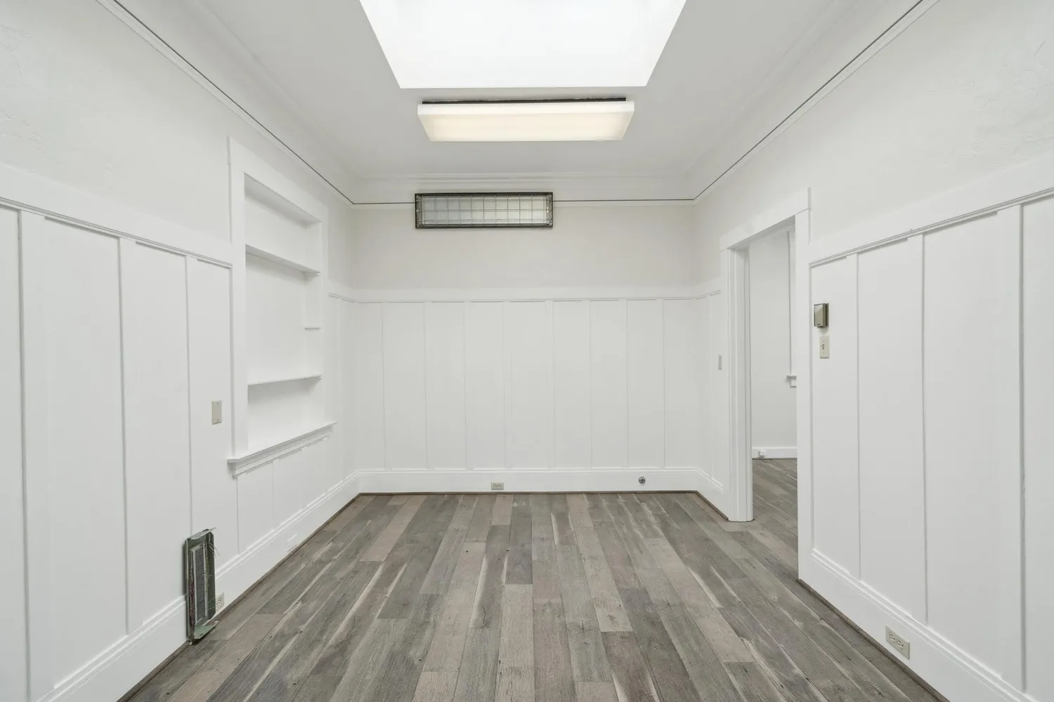 a view of empty room with wooden floor