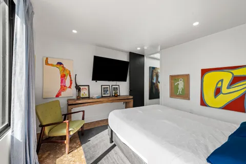 a bedroom with a bed and a flat screen tv