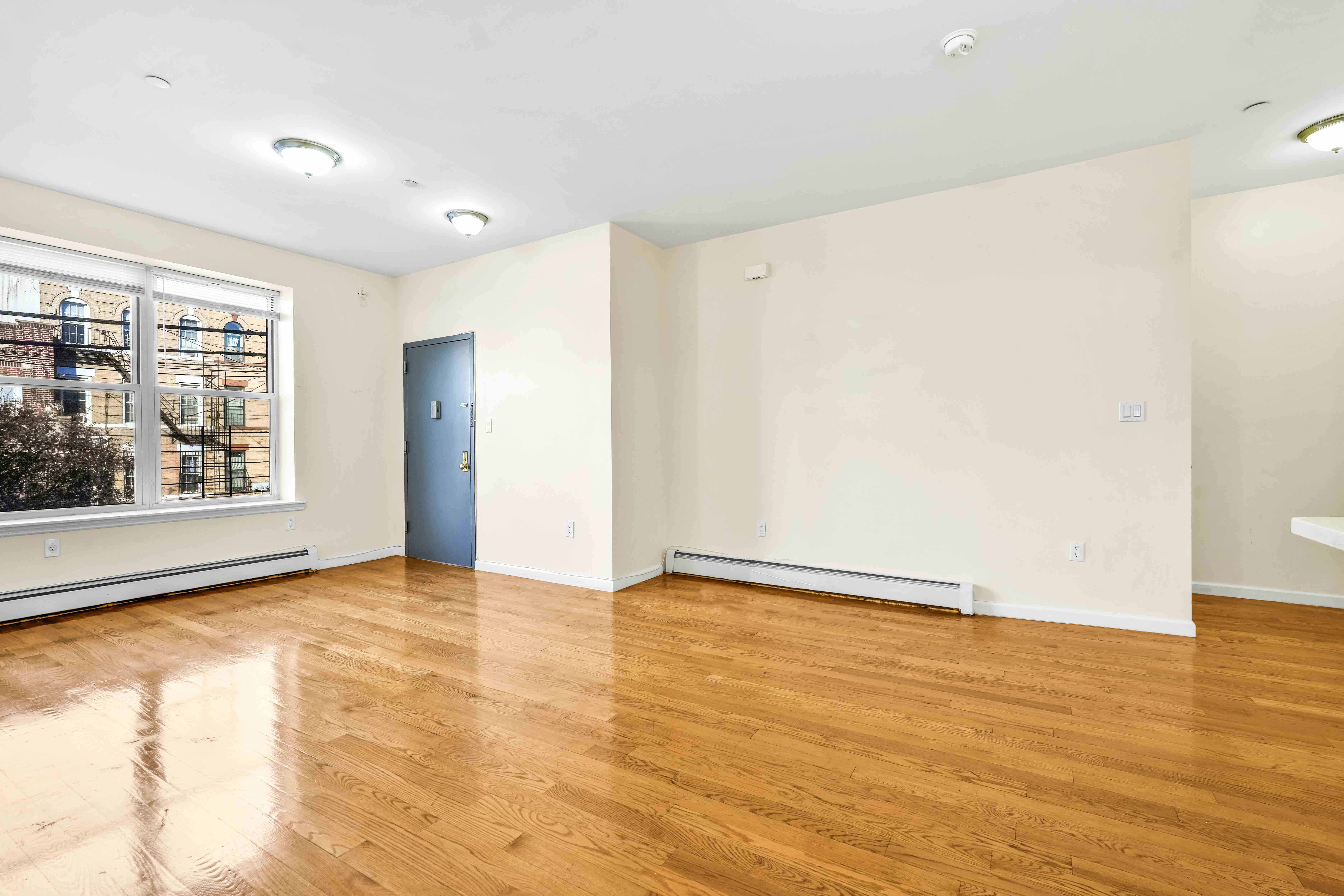1892 Bergen Street, Unit 2 Brooklyn, NY 11233 - Photo 12 of 24 a view of an empty room with wooden floor and a window
