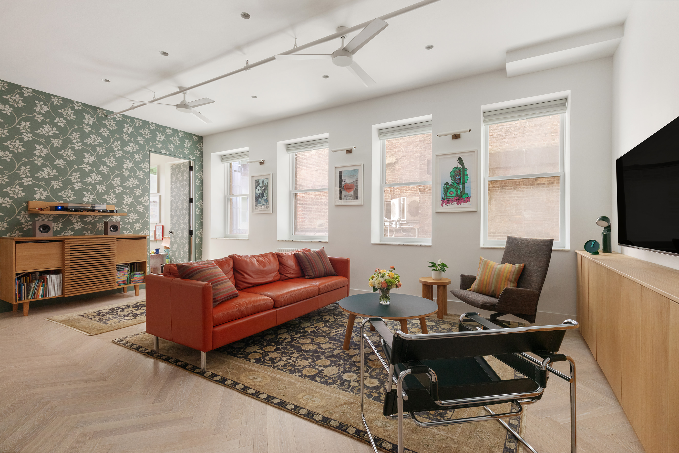 143 West 27th Street, Unit 2R Manhattan, NY 10001 - Photo 2 of 13 a living room with furniture a flat screen tv and a window