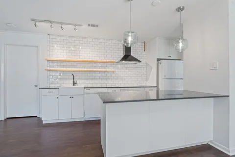 a kitchen with a sink a refrigerator and window