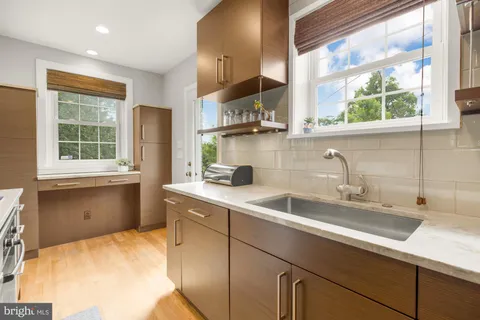 a kitchen with a sink a window and cabinets