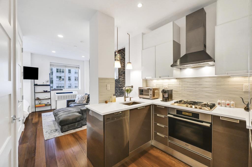 a kitchen that has a sink a stove and cabinets