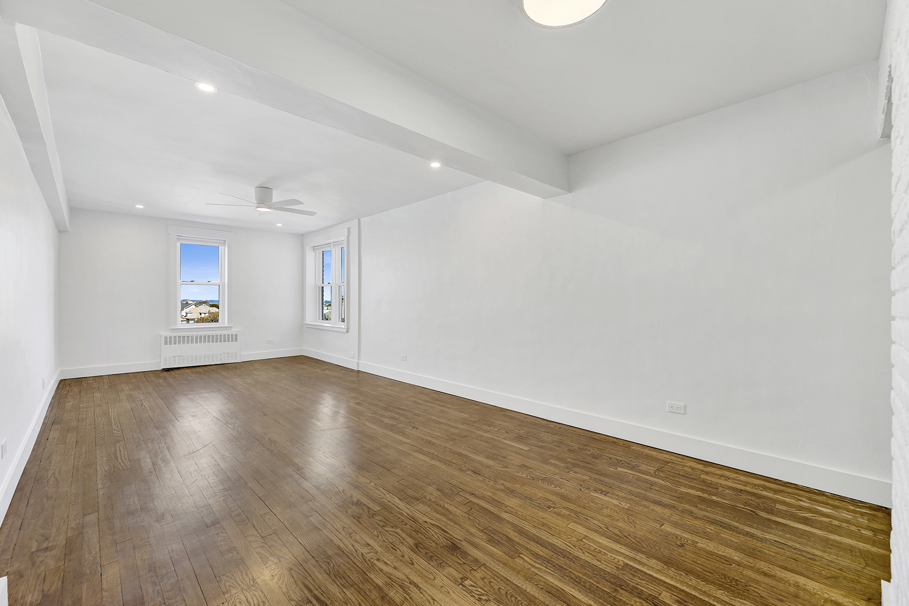 125 Beach 124th Street, Unit 5K Queens, NY 11694 - Photo 8 of 21 an empty room with wooden floor and windows
