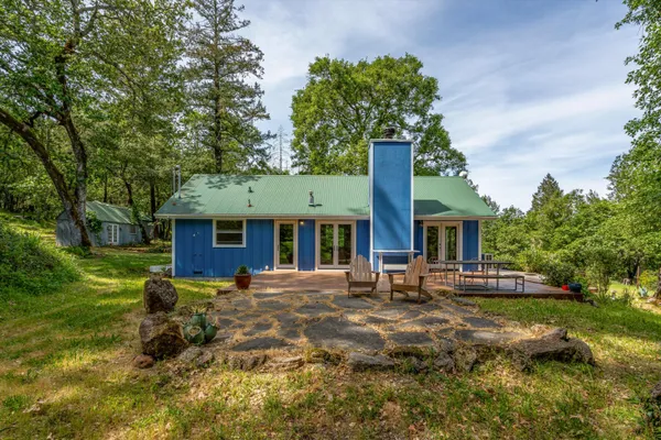 a backyard of a house with table and chairs