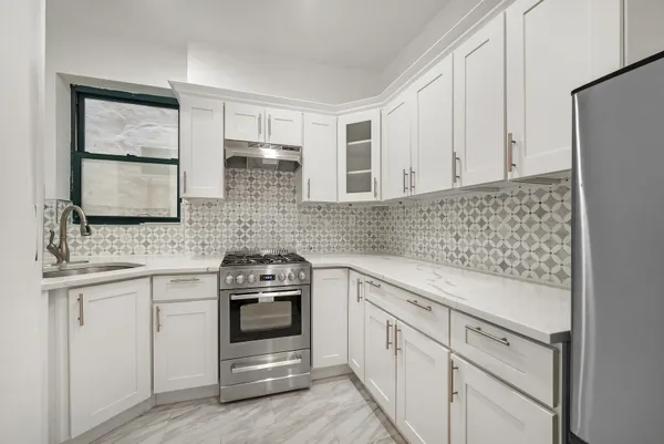 a kitchen with white cabinets and appliances