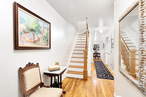 a view of a hallway with furniture and wooden floor