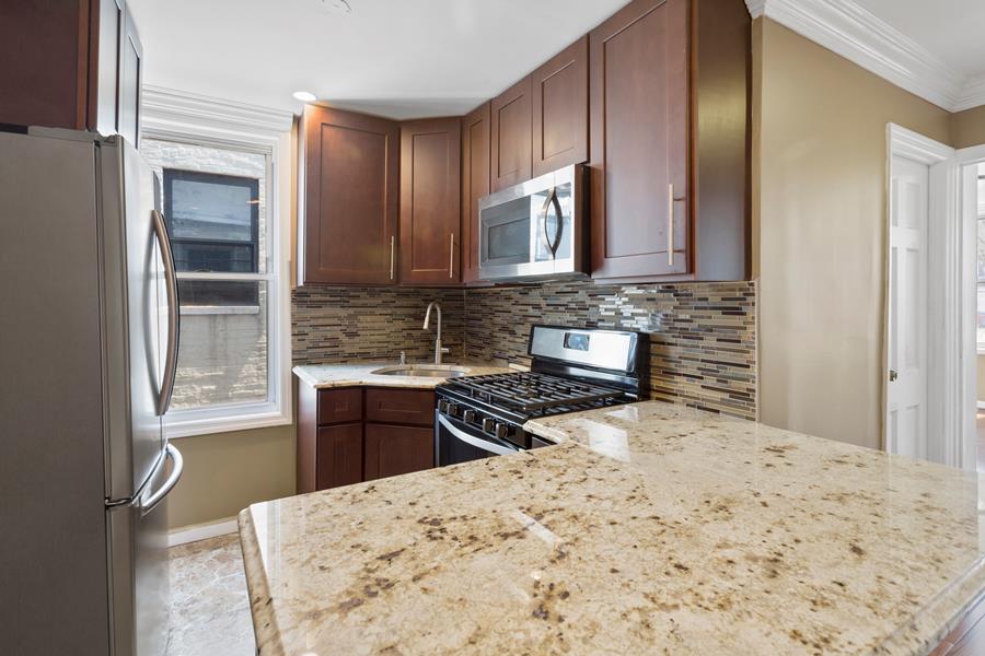 11-15 30th Drive, Unit 2F Queens, NY 11102 - Photo 2 of 6 a kitchen with a stove a sink and a refrigerator