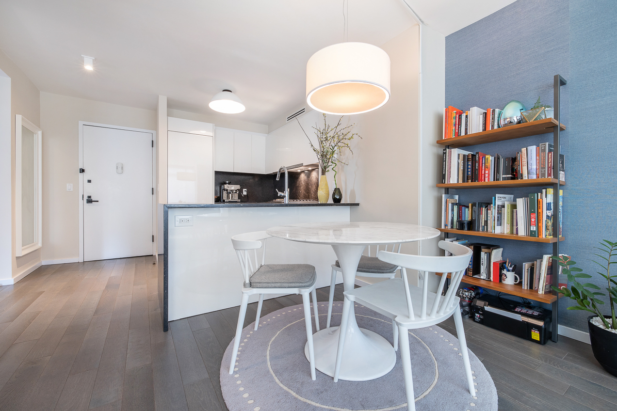 385 1st Avenue, Unit 6G Manhattan, NY 10010 - Photo 4 of 19 a view of a dining room with furniture and a book shelf