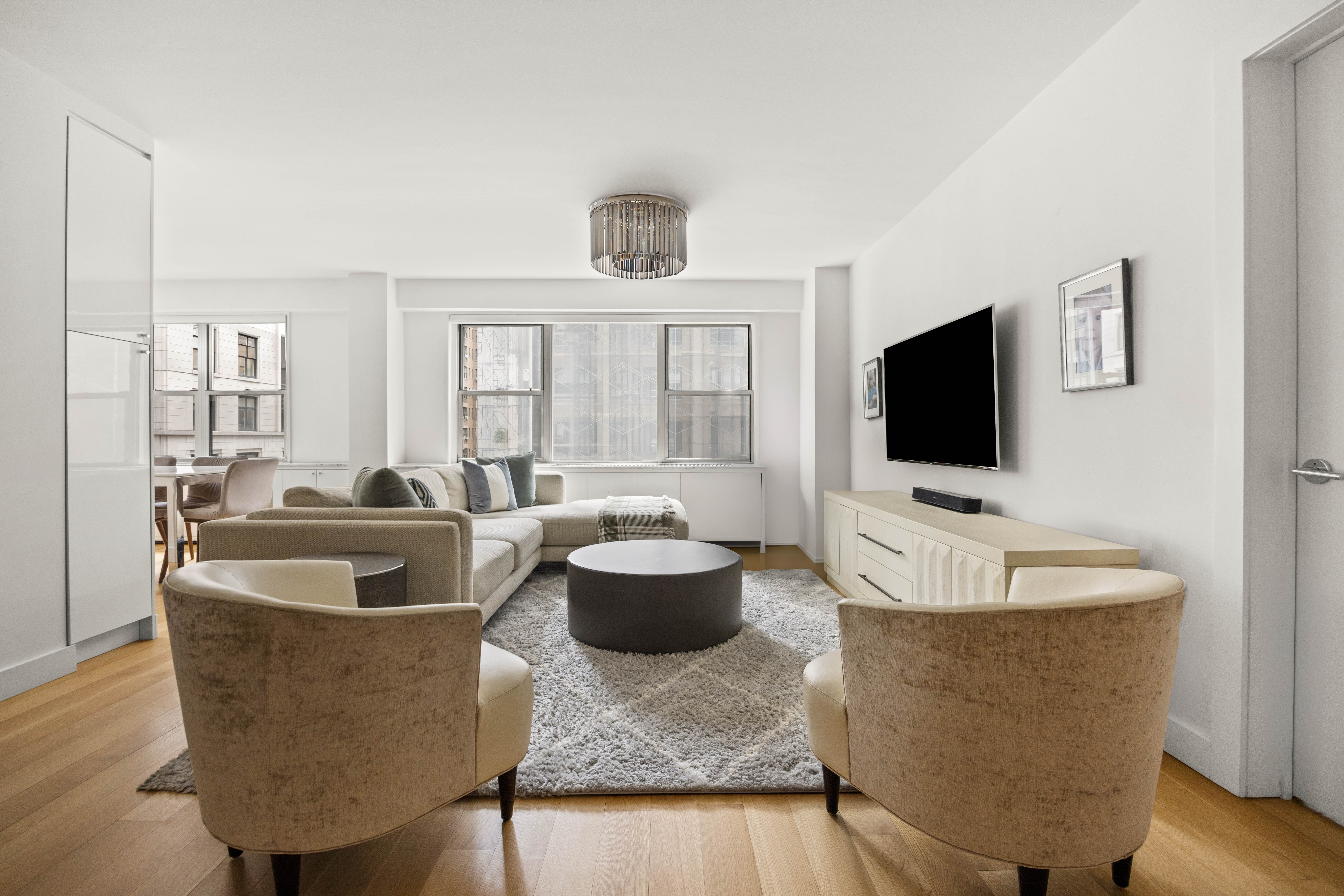 136 East 56th Street, Unit 4EF Manhattan, NY 10022 - Photo 3 of 10 a living room with furniture and a flat screen tv