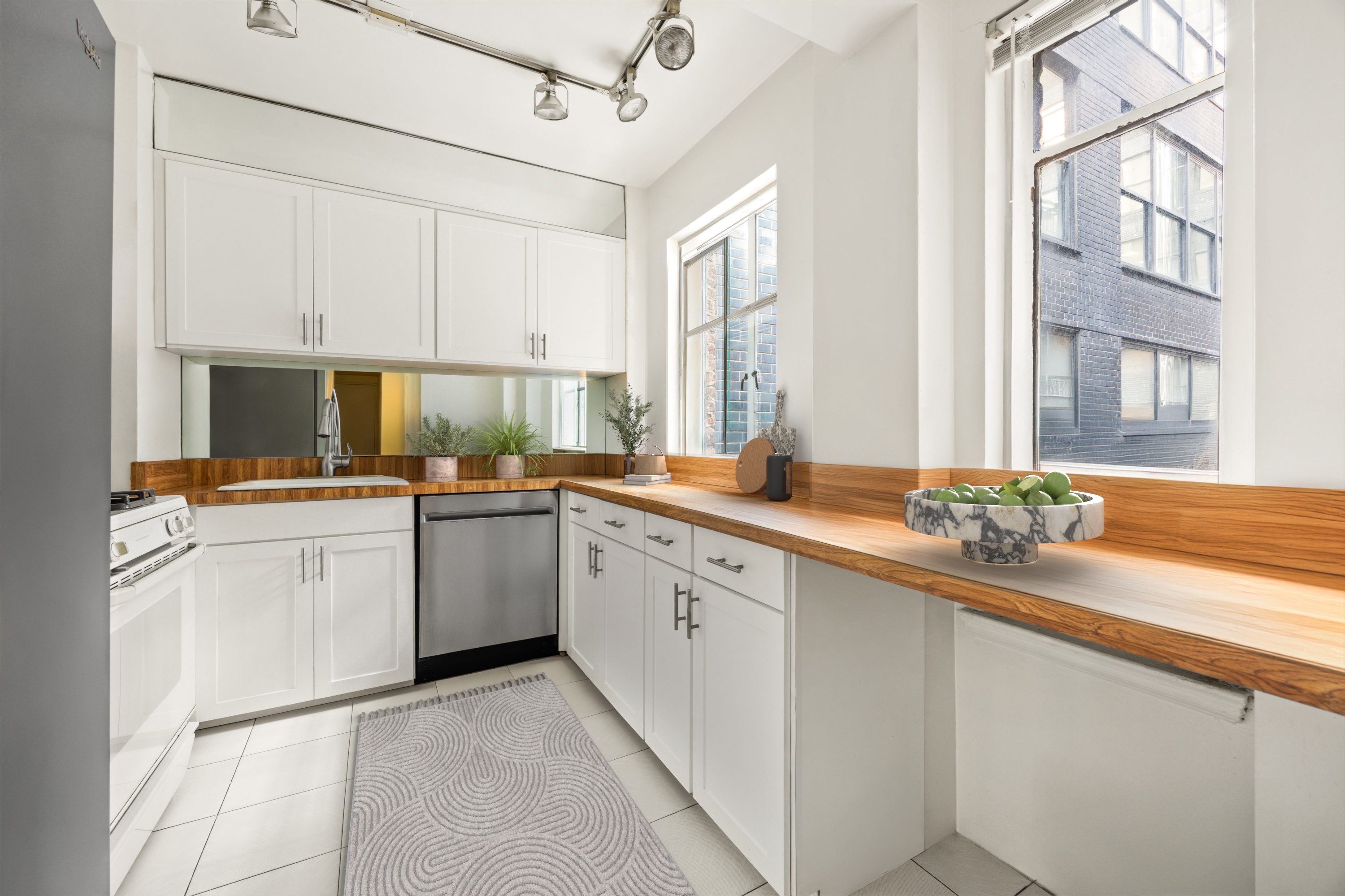 45 West 54th Street, Unit 9E Manhattan, NY 10019 - Photo 3 of 9 a kitchen with white cabinets and appliances