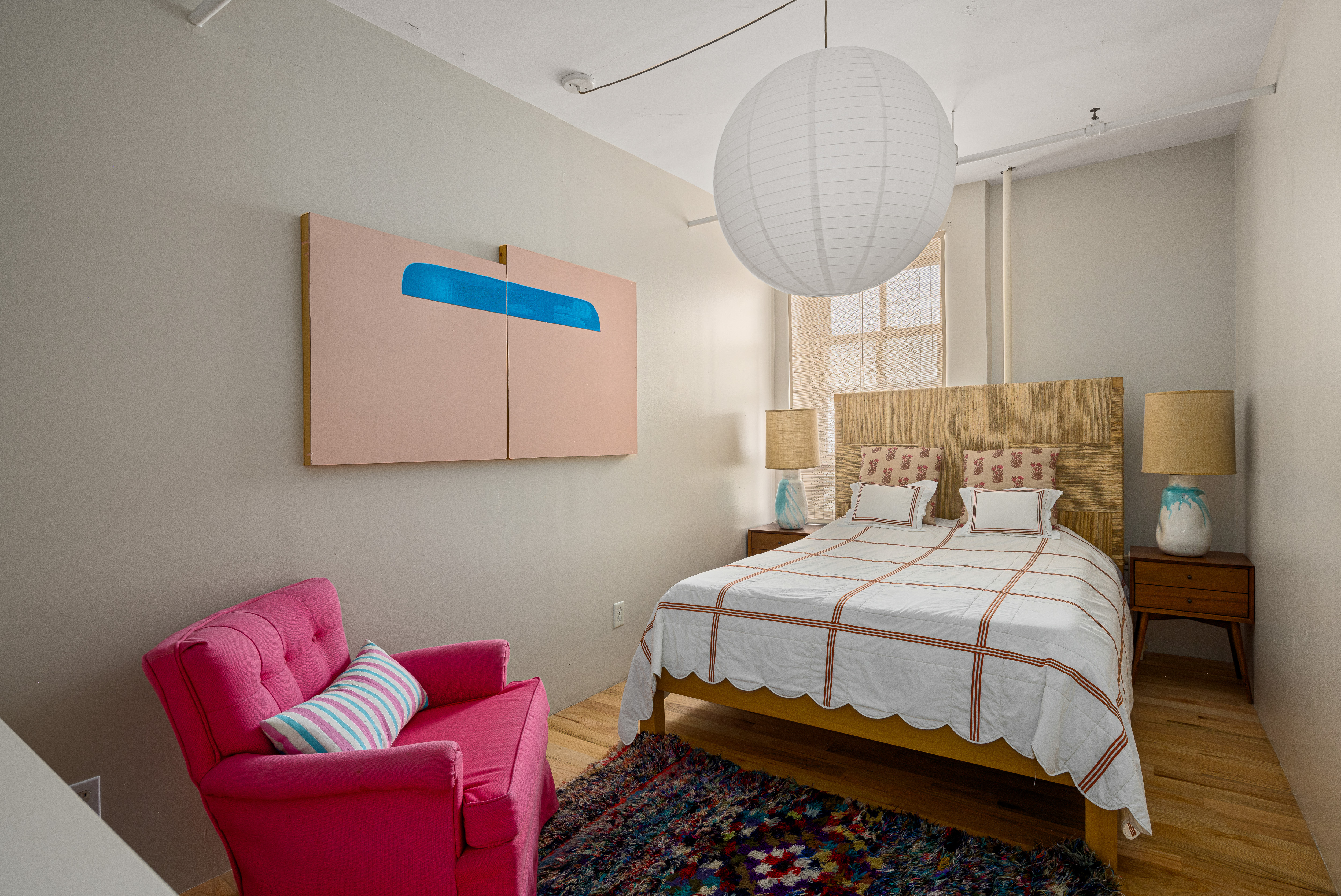 191 Chrystie Street, Unit 5R Manhattan, NY 10002 - Photo 10 of 16 a bedroom with a bed a couch and a chandelier