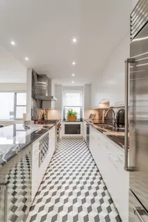 a large white kitchen with a sink and refrigerator