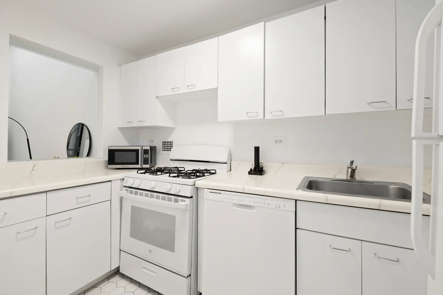 a kitchen with white cabinets and white appliances