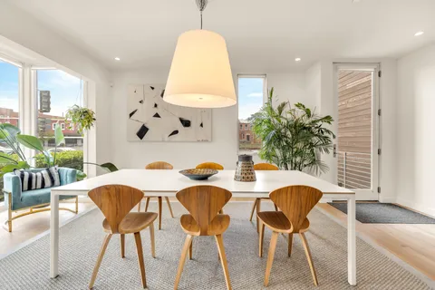 a view of a dining room with furniture and a potted plant