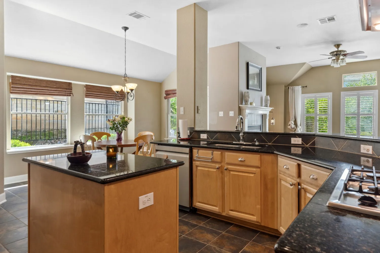 a kitchen with stainless steel appliances granite countertop a sink a stove and a wooden floors