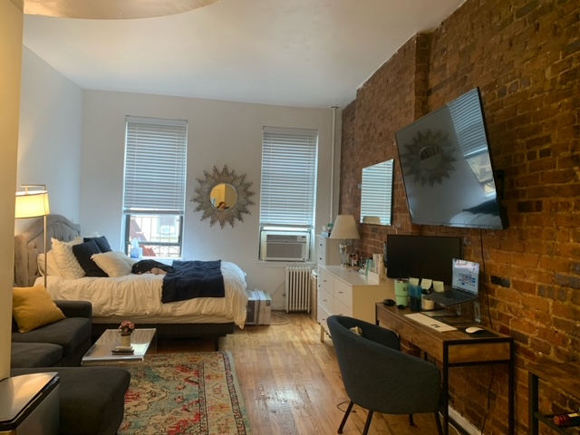 143 Sullivan Street, Unit 12 Manhattan, NY 10012 - Photo 4 of 11 a living room with furniture and a lamp