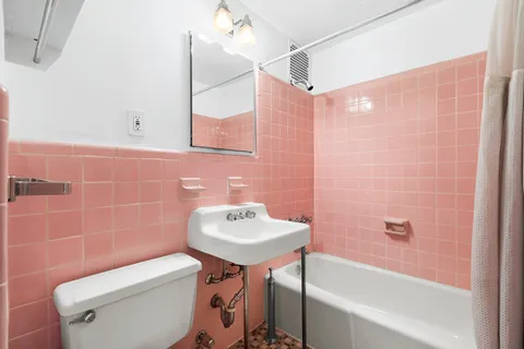 a bathroom with a sink a toilet a mirror and bathtub
