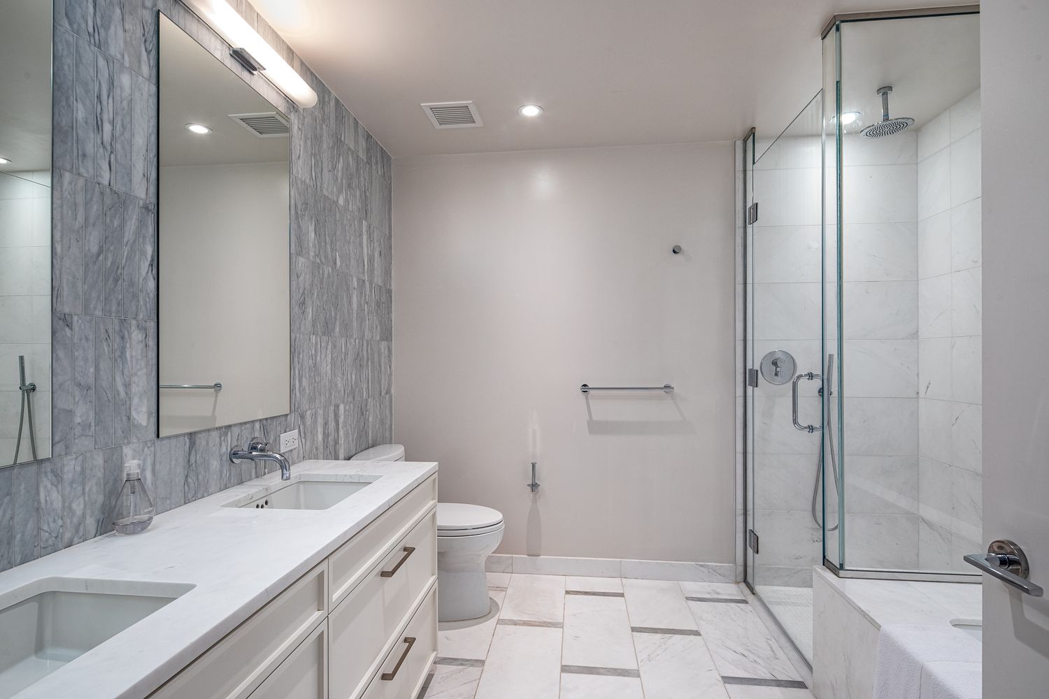 160 East 22nd Street, Unit 15C Manhattan, NY 10010 - Photo 4 of 6 a bathroom with a double vanity sink toilet and shower