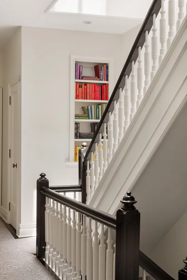 a view of staircase with wooden floor and white walls