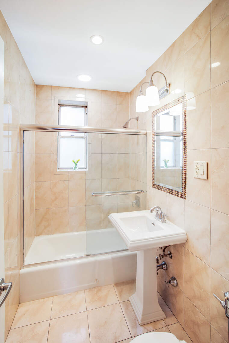 9801 Shore Road, Unit 2B Brooklyn, NY 11209 - Photo 5 of 13 a bathroom with a sink a bathtub and a shower