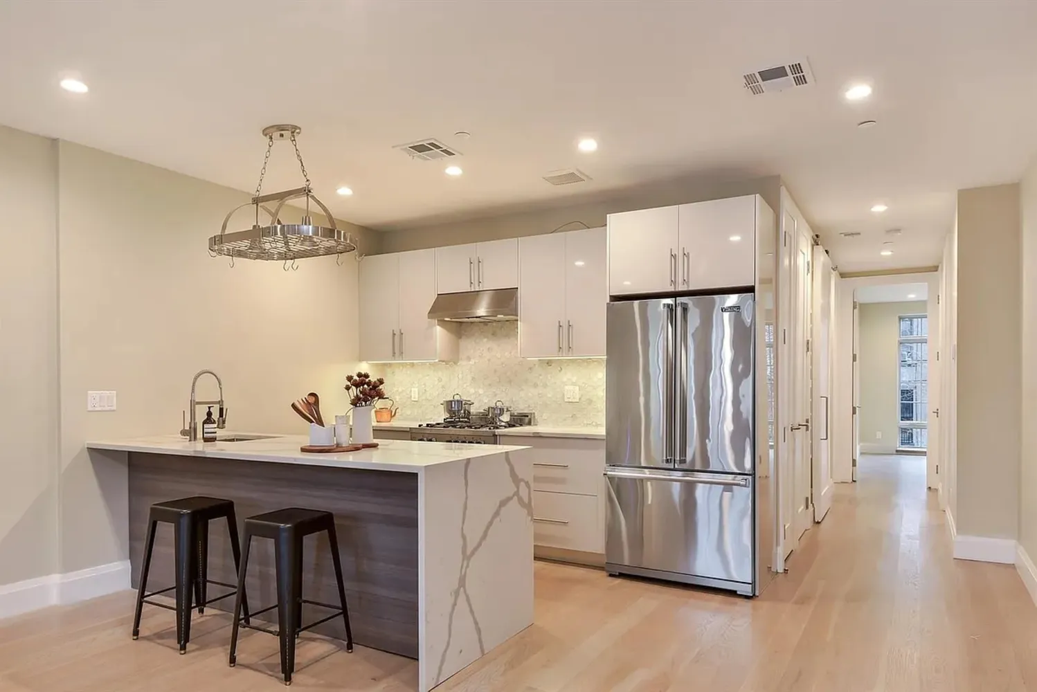 a kitchen with kitchen island white cabinets and stainless steel appliances